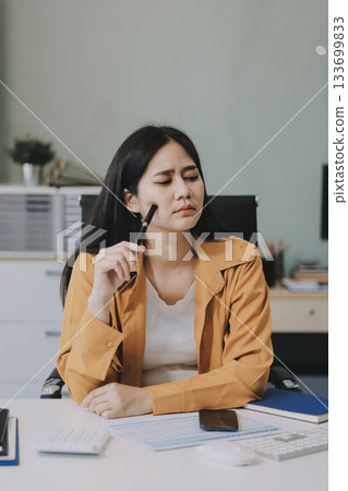 Business woman using calculator for do math finance on wooden desk in office and business working background, tax, accounting, statistics and analytic research concept. 133699833