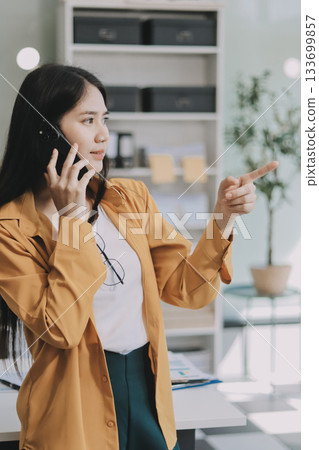 Business woman using calculator for do math finance on wooden desk in office and business working background, tax, accounting, statistics and analytic research concept. 133699857