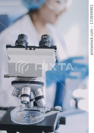 Portrait, science and happy woman on laptop in lab to research chemistry, test or innovation. Microscope, scientist and face of medical doctor in goggles for microbiology, healthcare or pharma study 133699901