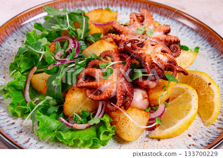 Grilled octopus with baked potatoes and fresh herbs, on a decorative plate, homemade, Grilled octopus with baked potatoes and fresh herbs, on a decorative plate, homemade, 133700229