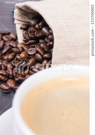 Coffee in white cup and roasted dark coffee beans in bag Coffee in white cup and roasted dark coffee beans in bag 133700905