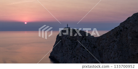Dramatic sunset over the lighthouse of Cap de Formentor, Mallorca. The orange glow of the Mediterranean Sea captured from high cliffs in stunning high resolution. perfect for fine art prints. Dramatic sunset over the lighthouse of Cap de Formentor, Mallorca. The orange glow of the Mediterranean Sea captured from high cliffs in stunning high resolution. perfect for fine art prints. 133700952