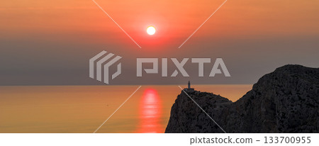 Dramatic sunset over the lighthouse of Cap de Formentor, Mallorca. The orange glow of the Mediterranean Sea captured from high cliffs in stunning high resolution. perfect for fine art prints. 133700955