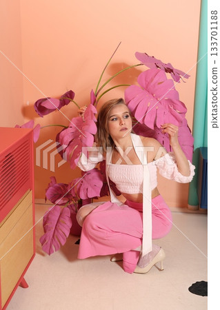 Confident lifestyle ambassador in pastel studio with plants Confident lifestyle ambassador in pastel studio with plants 133701188