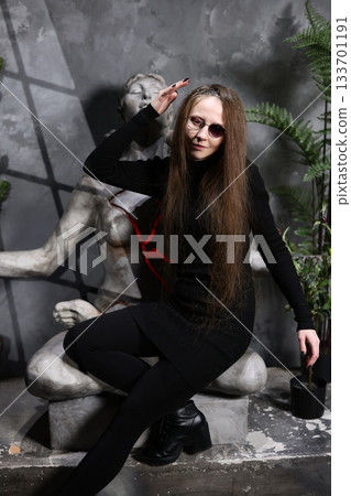 Enigmatic female figure surrounded by nature and faint red symbols 133701191