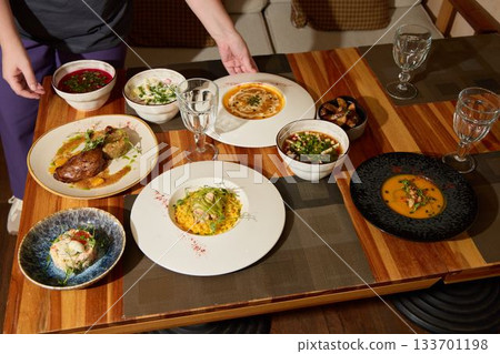 A Scrumptious Array of Gourmet Dishes Arranged Beautifully on a Wooden Dining Table 133701198