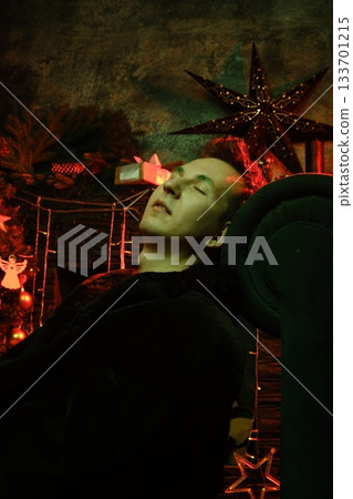 Youth seated on plush sofa surrounded by seasonal lights and ornaments Youth seated on plush sofa surrounded by seasonal lights and ornaments 133701215