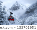 A red cable car gliding through a snowy mountain forest surrounded by mist and cliffs 133701951