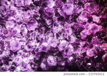 Vibrant amethyst crystal cluster with deep purple facets and sparkling geometric formations Vibrant amethyst crystal cluster with deep purple facets and sparkling geometric formations 133702012