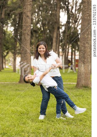 A woman and a little girl are playing in a park A woman and a little girl are playing in a park 133702193
