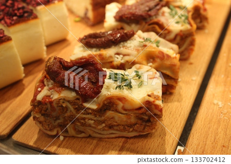 Close-up of lasagna in the window of a cafe shop. Close-up of lasagna in the window of a cafe shop. 133702412