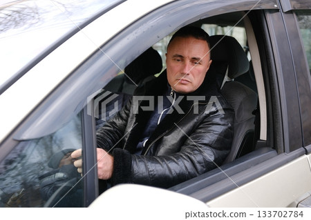 The man looks after the car from all sides, opens the doors and gets into it. man polishes a black car with a polisher The man looks after the car from all sides, opens the doors and gets into it. man polishes a black car with a polisher 133702784