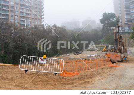 White brick fence on a ground dug out on a foggy day with tall buildings in the background White brick fence on a ground dug out on a foggy day with tall buildings in the background 133702877