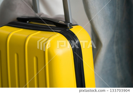 A small suitcase in a yellow color closeup, a travel bag at the airport. 133703904