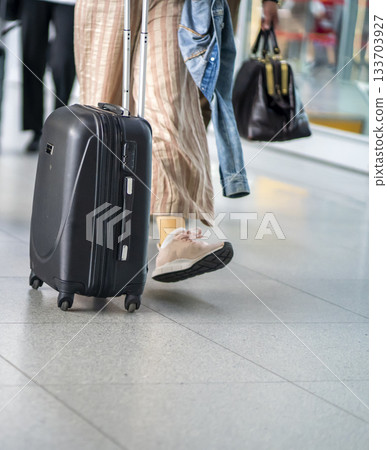 People walk with suitcases, travel bags at the airport. People walk with suitcases, travel bags at the airport. 133703927