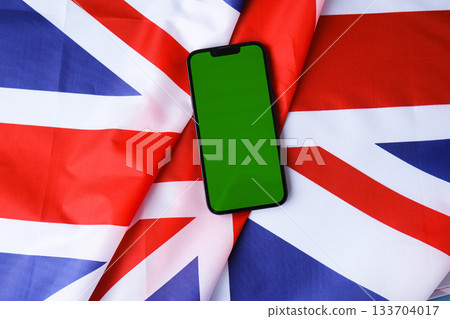 Green smartphone phone chromakey screen National symbol of Great Britain. Mock up advertisement template UK wave British fabric flag background. Copy space for your text. Independence 133704017