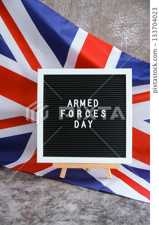 ARMED FORCES DAY patriotic scene with signboard and waving flag message UNITED KINGDOM with national colors Festive background with British flag and message board with text Great Britain. Remembrance ARMED FORCES DAY patriotic scene with signboard and waving flag message UNITED KINGDOM with national colors Festive background with British flag and message board with text Great Britain. Remembrance 133704023