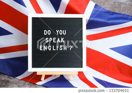 Message DO YOU SPEAK ENGLISH on background of Great Britain UK flag. British national flag with concept of High school university college education, language courses, online distance learning 133704031