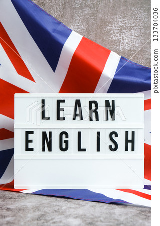 Message LEARN ENGLISH on background of Great Britain UK flag made from silk. British national flag with concept of tourism and traveling students opportunities scholarship programs Message LEARN ENGLISH on background of Great Britain UK flag made from silk. British national flag with concept of tourism and traveling students opportunities scholarship programs 133704036