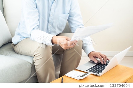 一位中年男子在客廳操作電腦 一位中年男子在客廳操作電腦 133704604