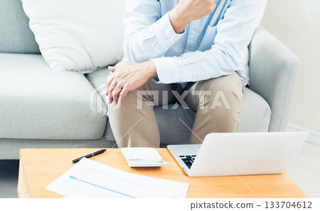 一位中年男子在客廳操作電腦 133704612