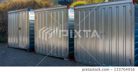 Row of metal storage containers outdoors in sunlight Row of metal storage containers outdoors in sunlight 133704916