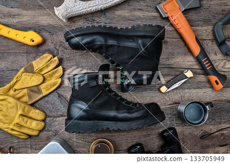 Outdoor boots and gear on a wooden table 133705949