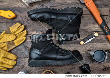 Outdoor boots and gear on a wooden table 133705950