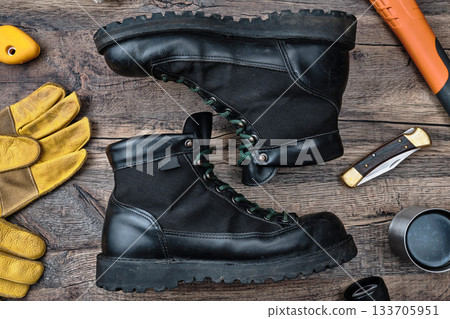 木桌上擺放著戶外靴和裝備。 133705951
