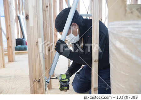 A carpenter installing a seismic damper 133707399