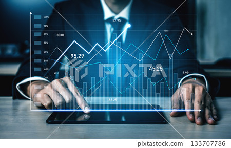 Business Analyst Interpreting Data Trends with Digital Tablet in Modern Workplace Environment with Financial Graphs and Metrics on Display Scalp 133707786