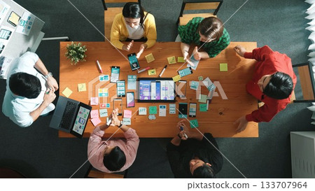 Top view designer present Ux Ui mobile phone interface at meeting. Convocation. 133707964