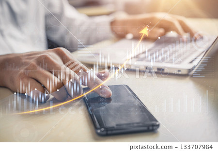 Businessman Analyzing Data Trends on Laptop with Smartphone in Office Setting for Financial Growth and Digital Innovation Scalp 133707984