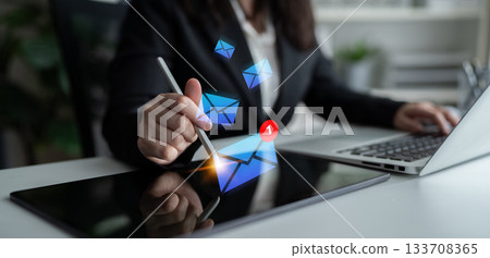 Business Professional Engaging with Digital Messaging on Tablet While Working on Laptop in Modern Office Environment Gantry Business Professional Engaging with Digital Messaging on Tablet While Working on Laptop in Modern Office Environment Gantry 133708365