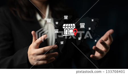 Businessman displaying digital map with store icons, showcasing location services for retail environments and market strategy development for ventures Gantry 133708401