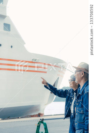 Portrait of a senior couple enjoying a trip in front of a ferry Portrait of a senior couple enjoying a trip in front of a ferry 133708592