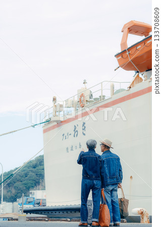 Travel image of a senior couple watching the ferry at the port Travel image of a senior couple watching the ferry at the port 133708609