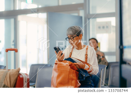 Senior woman waiting to depart at the ferry terminal Senior woman waiting to depart at the ferry terminal 133708744