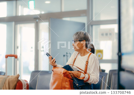 Senior woman waiting to depart at the ferry terminal Senior woman waiting to depart at the ferry terminal 133708746