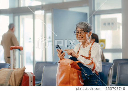 Senior woman waiting to depart at the ferry terminal Senior woman waiting to depart at the ferry terminal 133708748