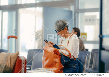 Senior woman waiting to depart at the ferry terminal Senior woman waiting to depart at the ferry terminal 133708749