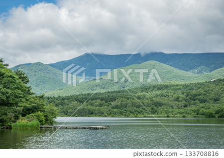A tranquil summer scene of Lake Baragi and lush green mountains in Tsumagoi Village 133708816