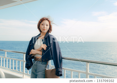 旅行場景:一位二十多歲的女子在渡輪甲板上感受海風。 旅行場景:一位二十多歲的女子在渡輪甲板上感受海風。 133709102