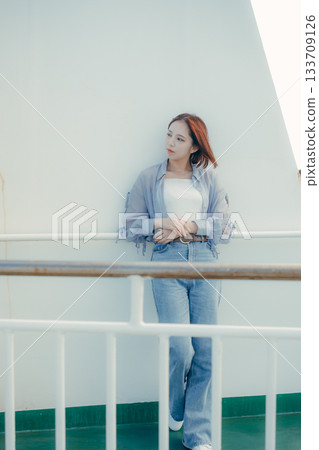 旅行場景：一位二十多歲的女子在渡輪甲板上感受海風。 133709126