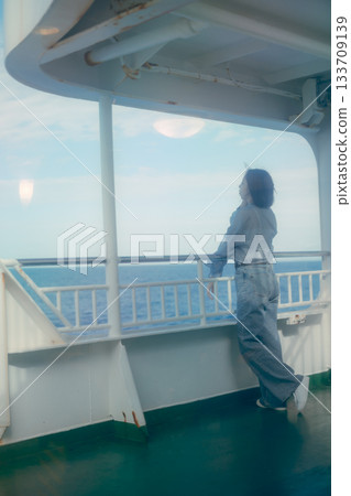旅行場景:一位二十多歲的女子在渡輪甲板上感受海風。 旅行場景:一位二十多歲的女子在渡輪甲板上感受海風。 133709139