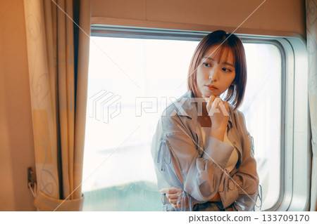 Travel scene of a woman in her twenties standing by the window on a ferry Travel scene of a woman in her twenties standing by the window on a ferry 133709170