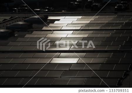 Solar Panels on Rooftop Reflecting Sunlight in Geometric Rows Solar Panels on Rooftop Reflecting Sunlight in Geometric Rows 133709351