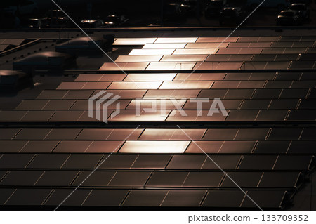 Solar Panels on Rooftop Reflecting Sunlight in Neat Rows Solar Panels on Rooftop Reflecting Sunlight in Neat Rows 133709352