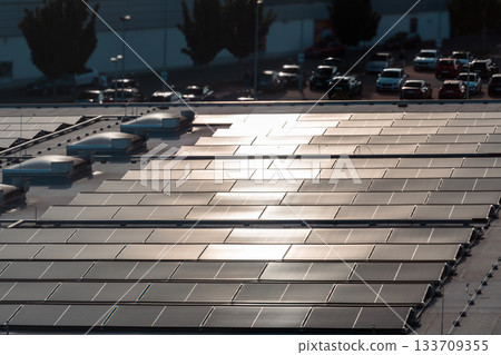 Large Rooftop Solar Panel Array with Urban Background and Reflections Large Rooftop Solar Panel Array with Urban Background and Reflections 133709355