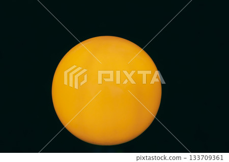 Bright Orange Sphere on Black Background with Smooth Gradient 133709361